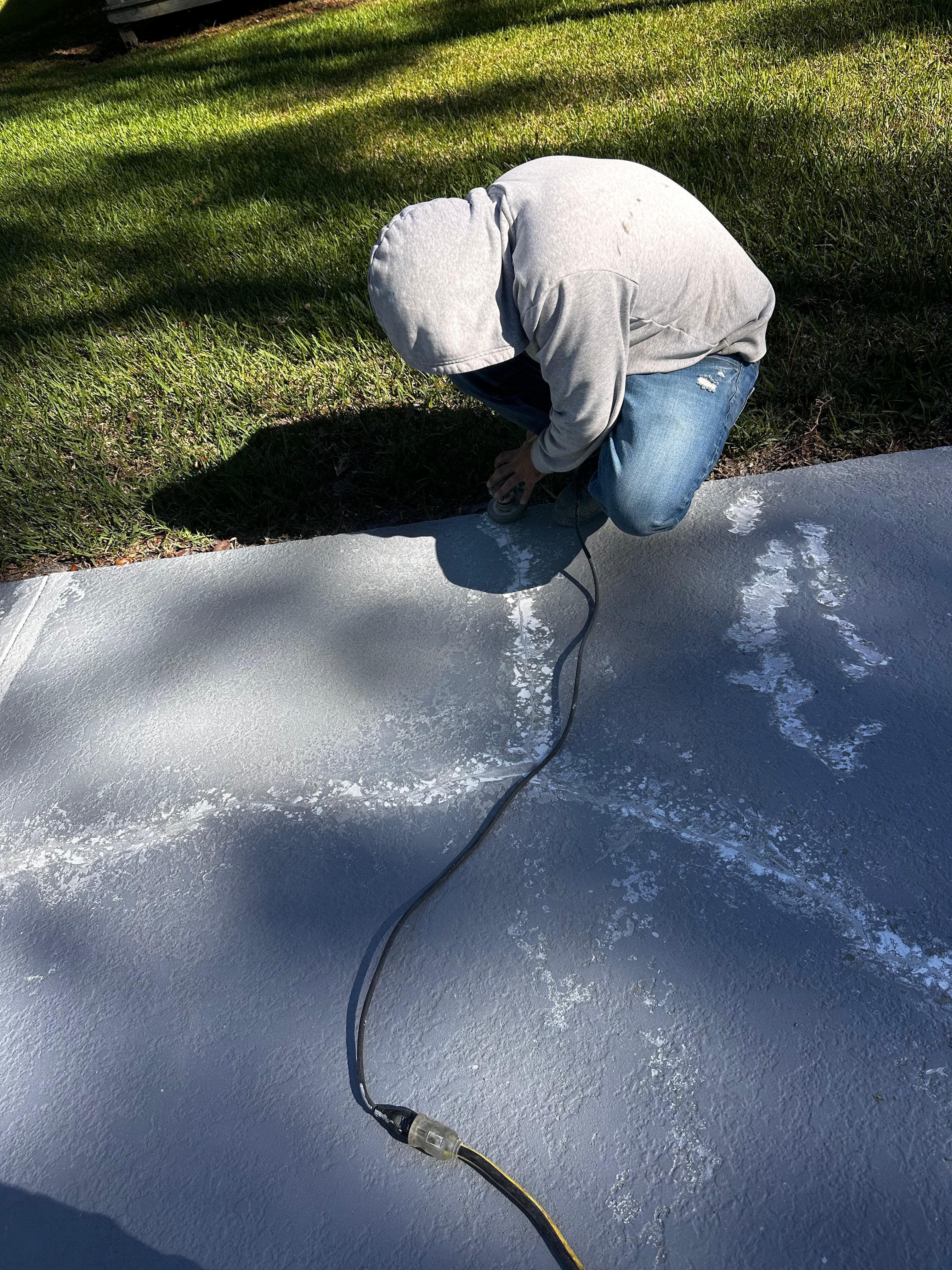 Technician grinding and repairing concrete pool deck cracks