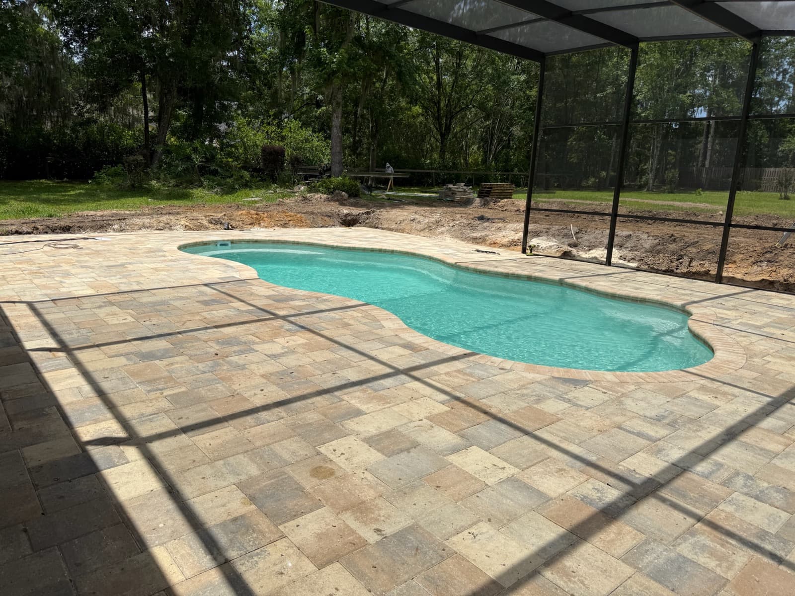 Laguna fiberglass pool installed by Cool Pool of Florida at a Gainesville FL home — paver deck and screen enclosure in Alachua County