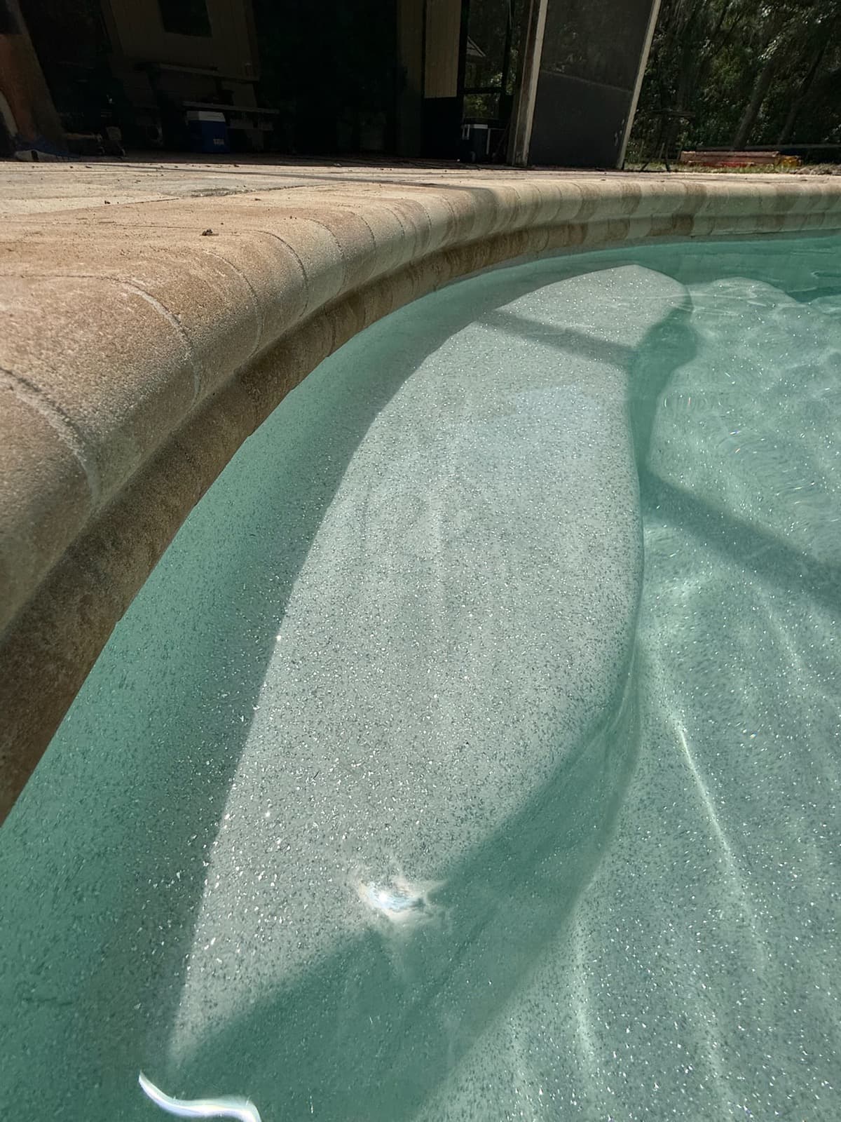 Close-up of the shimmer gelcoat finish and paver coping on a fiberglass pool installed in Gainesville FL