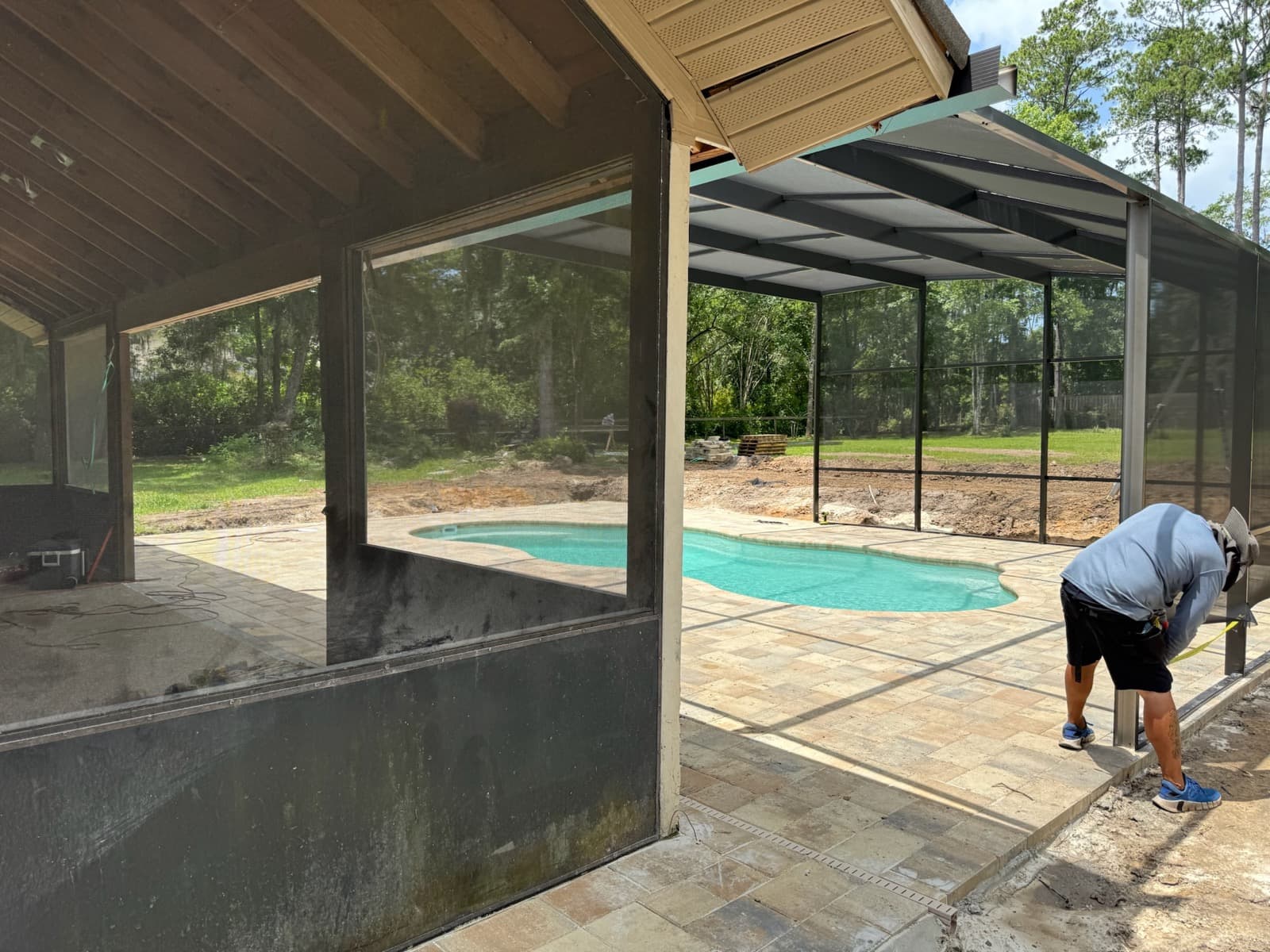Cool Pool of Florida crew finishing a fiberglass pool installation with screen enclosure at a Gainesville FL home