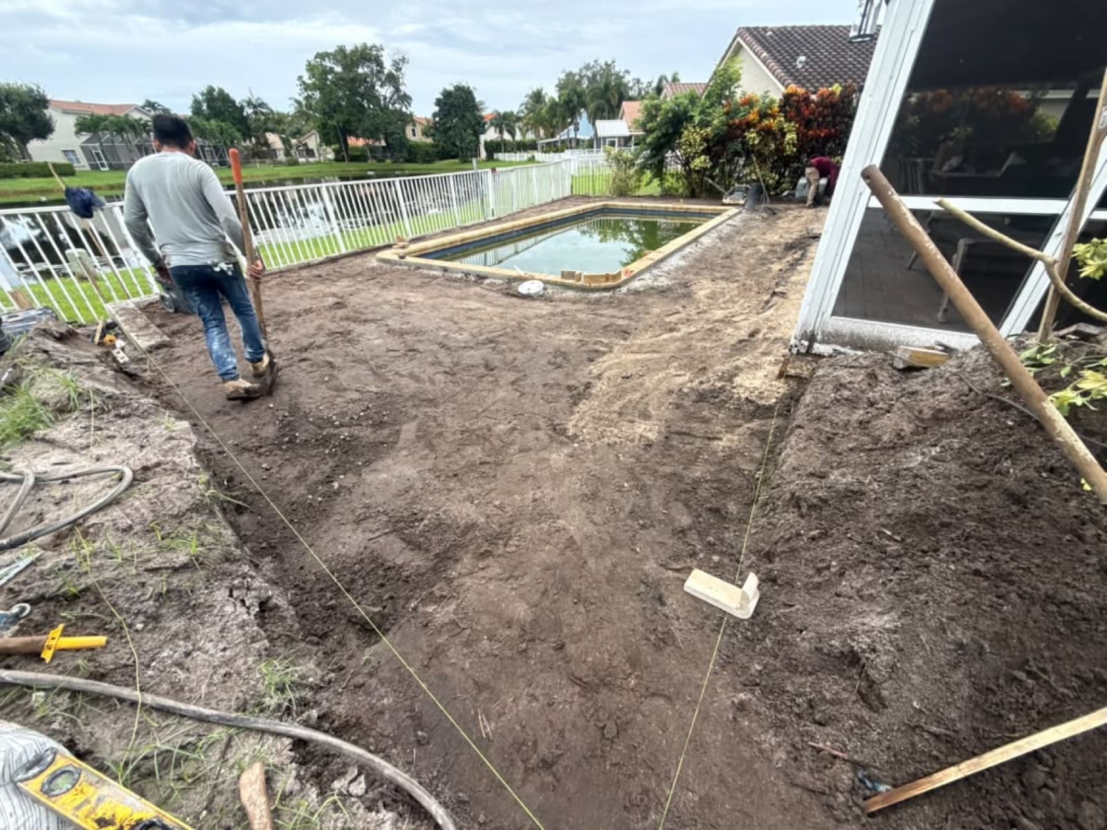Brick paver deck being installed around a new Latham Delray fiberglass pool in West Palm Beach FL